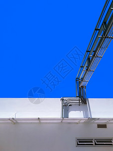 白色的建造力量垂直框中白色建筑对蓝亮天空的垂直框架高空气体金属管道系统的低角度视图图片