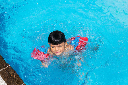 游泳者湿的健康小西班牙男孩在游泳池暑假图片