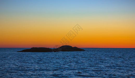 白色的位于奥内加湖白夜水面蓝色表的橙天空地平线背景上的一个小岛屿轮光环山黑暗的图片