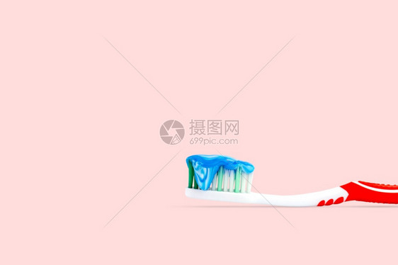 粉色的在红背景牙刷上查封一个蓝色和白牙膏以粉背景隔离的牙刷嘴颜色图片