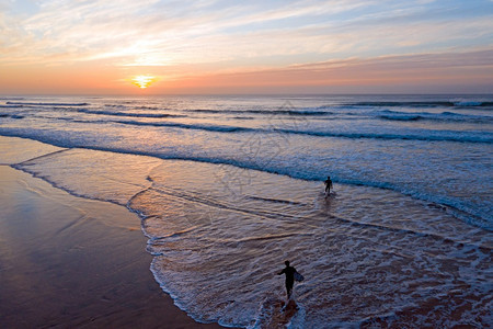 日落时从葡萄牙PraiaValeFigueiras出发谷反射冲浪图片