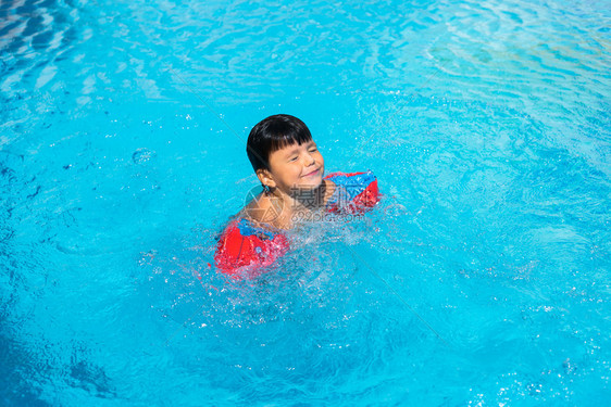 乐趣童年小西班牙男孩在游泳池暑假家庭图片