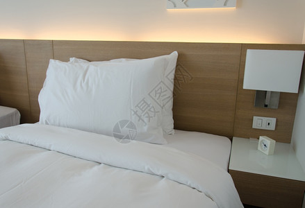 舒适国内的建筑学卧室有枕头和床边的阅读灯图片