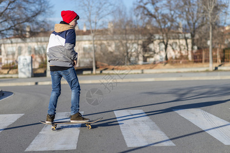 车轮肖像青少年在日出城市玩滑板练习沥青图片
