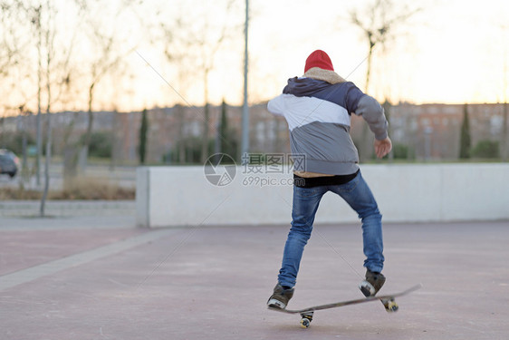 闲暇路沥青少年在日出城市玩滑板练习图片