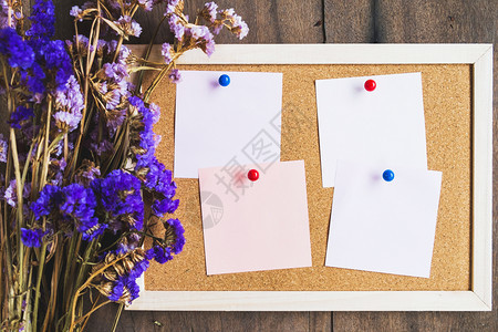 商业黄色的软木板上白纸条有干鲜花束和木本底信图片