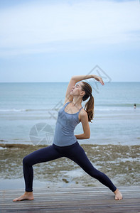 海边瑜伽的年轻女子图片