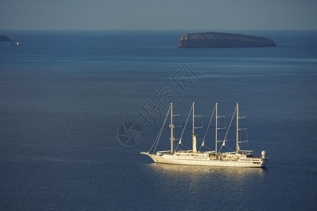 在希腊圣托里尼岛附近深蓝水域航行的帆船假期旅血管图片