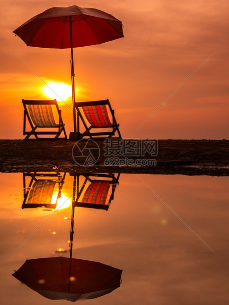 太阳升起海面上有橙色的清晨天空泰国水中海滩反射上有椅子和雨伞冷静的私人阳光图片