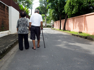 快乐的浪漫老年亚裔夫妇在村里散步和手牵走在路上高龄夫妇的概念互相照顾对方关心疾病步行图片