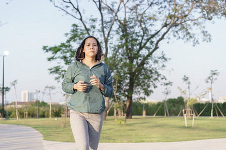路活力运动员亚洲妇女在早园健康生活方式和体育概念中慢跑的亚裔妇女图片