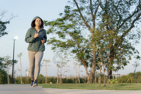 积极的女孩活力亚洲妇在早园健康生活方式和体育概念中慢跑的亚裔妇女图片