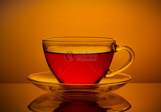热的早晨喝杯橙色背景的清茶一杯新鲜图片