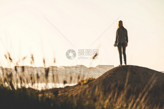 自然步行海岸女人有黄色的帽子享受着风景图片