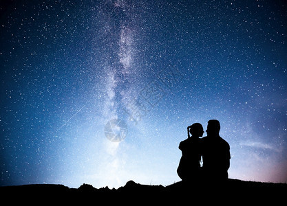 爬坡道银河与人的剪影夜晚星空的景观站在山上的男女与星光拥抱情侣对着紫色的银河美丽宇宙与人的剪影夜晚星空站在山上与星的男人和女对紫图片
