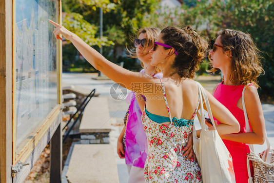 白种人3名女旅游客在暑假信息介绍日观看希腊旅游目的地信息面板上图点以了解休假日信息方向7月1日至630太阳镜旅行图片