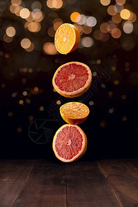 热带成熟的橙子和葡萄果饼切片的创意形象落在棕色生锈木制桌上背景有bokoh灯光林新鲜图片
