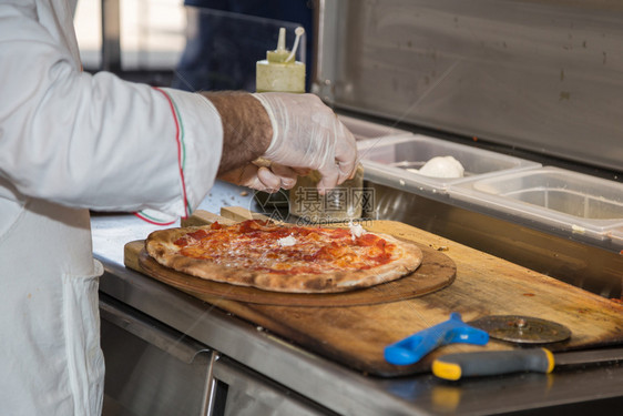面团厨房披萨制造者他准备了美味的比萨饼与奶酪莫扎里拉和番茄比萨制造者一起准备了美味的比萨与奶酪莫扎里拉和番茄酱图片