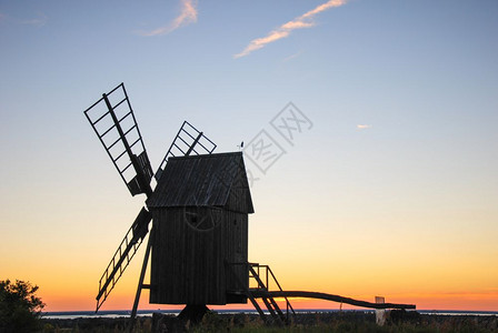 日落前的老木制风车图片