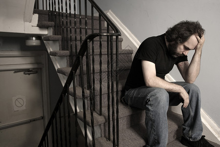 坐在公寓楼梯井的压倒忧郁症男成年人不饱和在医院里失败成人情感图片