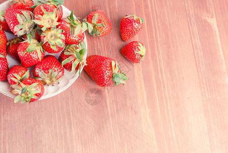 生的木制背景上新鲜草莓的盘子木制背景上成熟的草莓健康饮食维他命果味图片