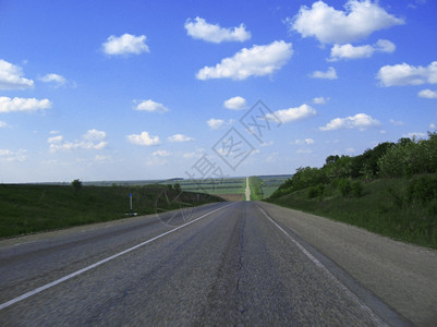 白色的驾驶全景横宽高速公路和草地云穿越蓝天空图片