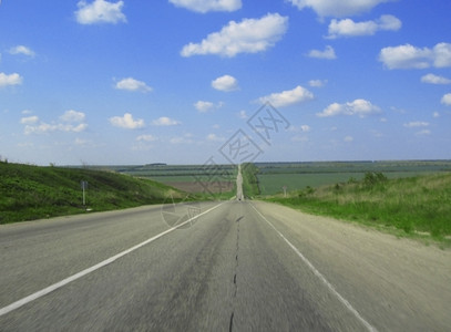横宽的高速公路和草地云穿越蓝天空超过气全景图片