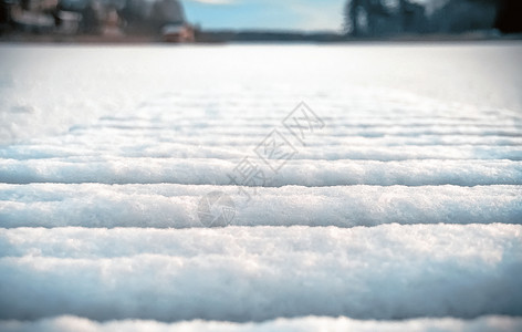 寒冷的冬季背景雪在湖上桥板排成一的结冰在阳光明媚的一天选择焦点模糊的冬雪背景有质感的铺板闪亮图片