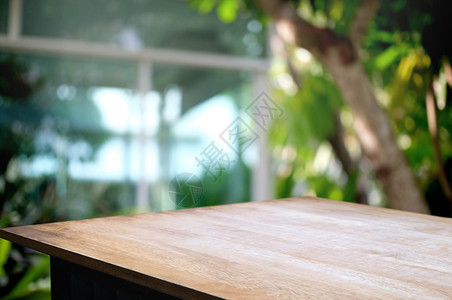 木制的绿色花园背景含模糊咖啡店或餐馆的空木板桌顶绿花园背景明亮的质地图片
