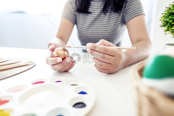 妈手妇女用白桌绘画东方鸡蛋女图片