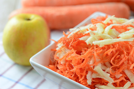 美味的切割甜健康沙拉概念紧闭地用苹果在白色盘子上加点胡萝卜背景图片