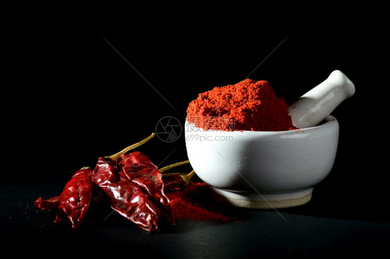 干燥成熟粉末中的红辣椒黑底有迫击和红辣椒粉色的图片
