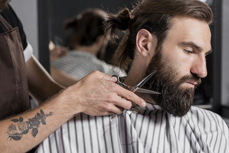 剪男客户胡子的美发店裁缝理师白种人剃须工作图片