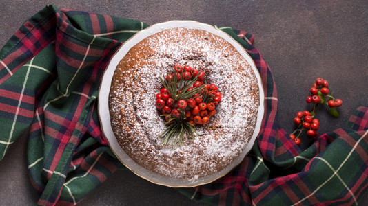 传统的美味平铺圣诞蛋糕和红莓躺着图片