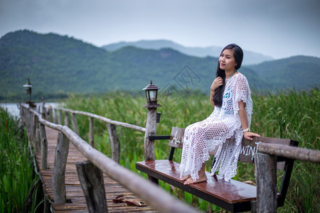 日出绿色木头坐在码上的女人看着日落的美丽图片