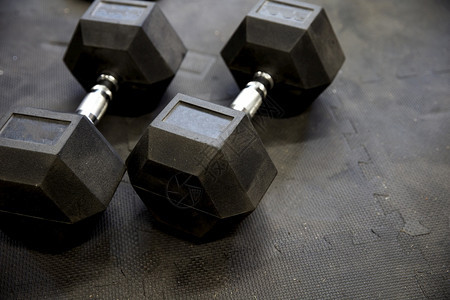 健身房内黑色橡胶地砖上的哑铃或重物健身概念特写里面为了运动的图片