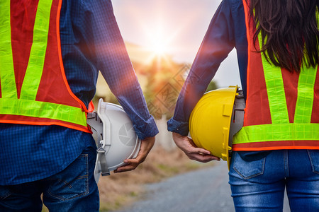 建造持有硬干安全软件的男工和女程师常户外团队工作管理项目建筑师绿色图片