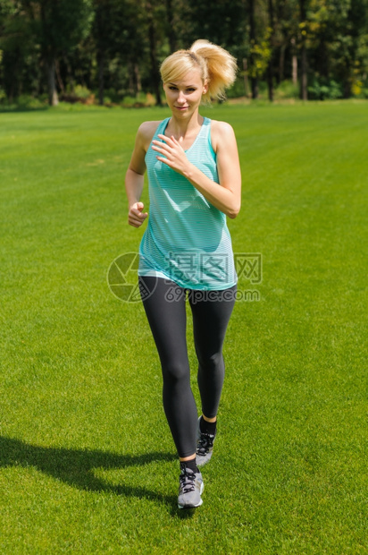 肖像慢跑者一位活跃的美丽天主教女在公园户外奔跑运动服图片