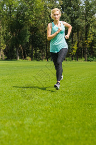 成人一位活跃的美丽天主教女在公园户外奔跑火车运动图片