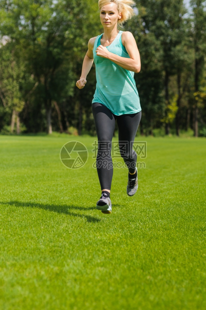竞技慢跑者一位活跃的美丽天主教女在公园户外奔跑金发图片