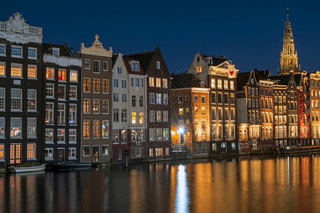 游客沿荷兰达布拉克河沿阿姆斯特丹的房屋城市反射图片