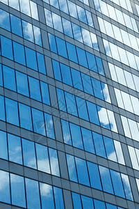 摩天大楼结构体角度云和天空在玻璃建筑表面的反射图片