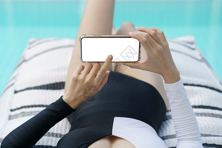 泳装女子在游池看手机屏幕图片