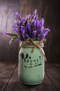 植物补救罐以旧木形背景隔绝的复古花瓶形式盛装的熏衣花束图片