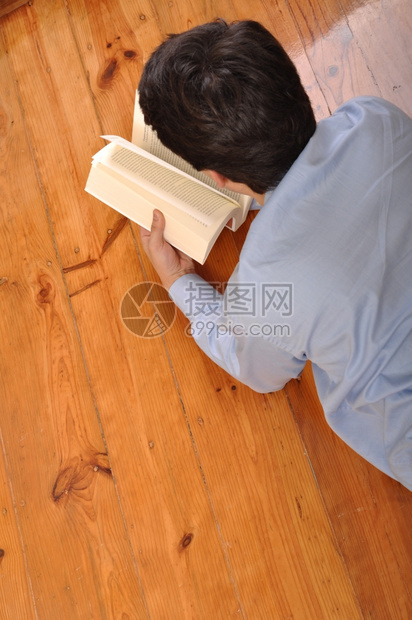 成人衬衫一名年轻躺在家里地板上看一本商业书的背面景象文学图片