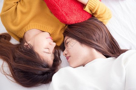 在白床上的年轻亚洲女青与幸福的时刻李斯比情侣概念女士家庭图片