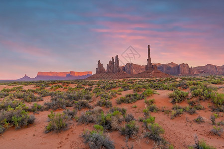 风景红色的美国亚利桑那州日落时美国古迹谷的Totem极和沙丘部落的图片