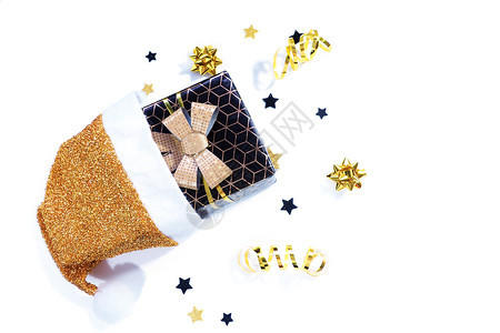假期平坦的圣诞节黑礼物盒带有几何图案和金弓的黑色礼品盒从一个金白色圣诞帽子上掉下来星糖果蛇弦白底面有阴影的箭头图片