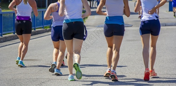 年轻女孩团体朋友在市街上奔跑户外训练积极的图片