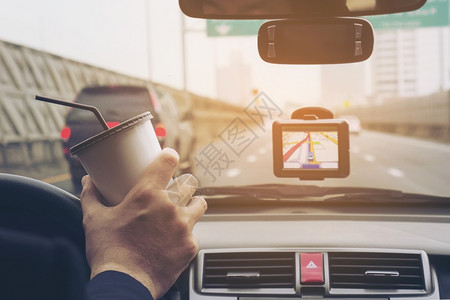 男子驾驶车使用导航员和咖啡杯路亚洲人屏幕背景图片
